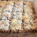 7 Layer Magic Bars being sliced from the whole baked sheet