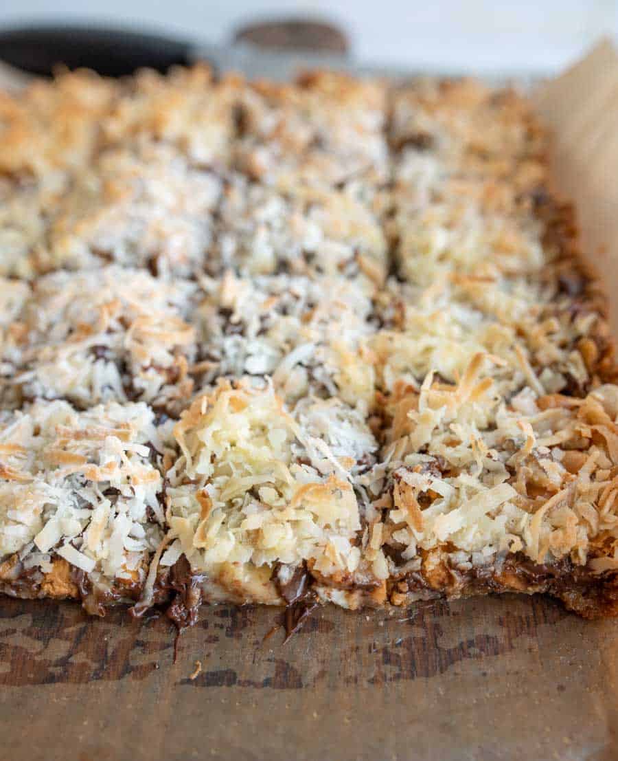 7 Layer Magic Bars being sliced from the whole baked sheet