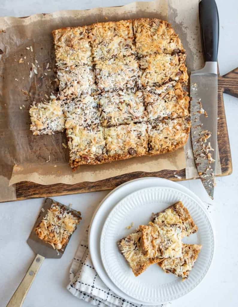 7 Layer Magic Bars being sliced in squares from the whole baked sheet