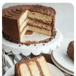 pin for white cake recipe with a view of the whole cake iced in chocolate and two wedges served