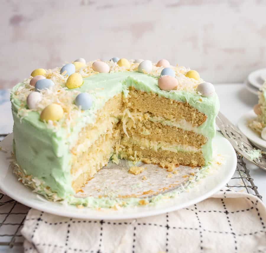 close up of the whole coconut easter cake with slices missing