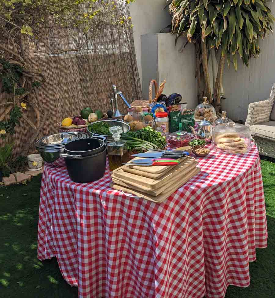 red checkered table set for a cooking class with lots of cutting boards