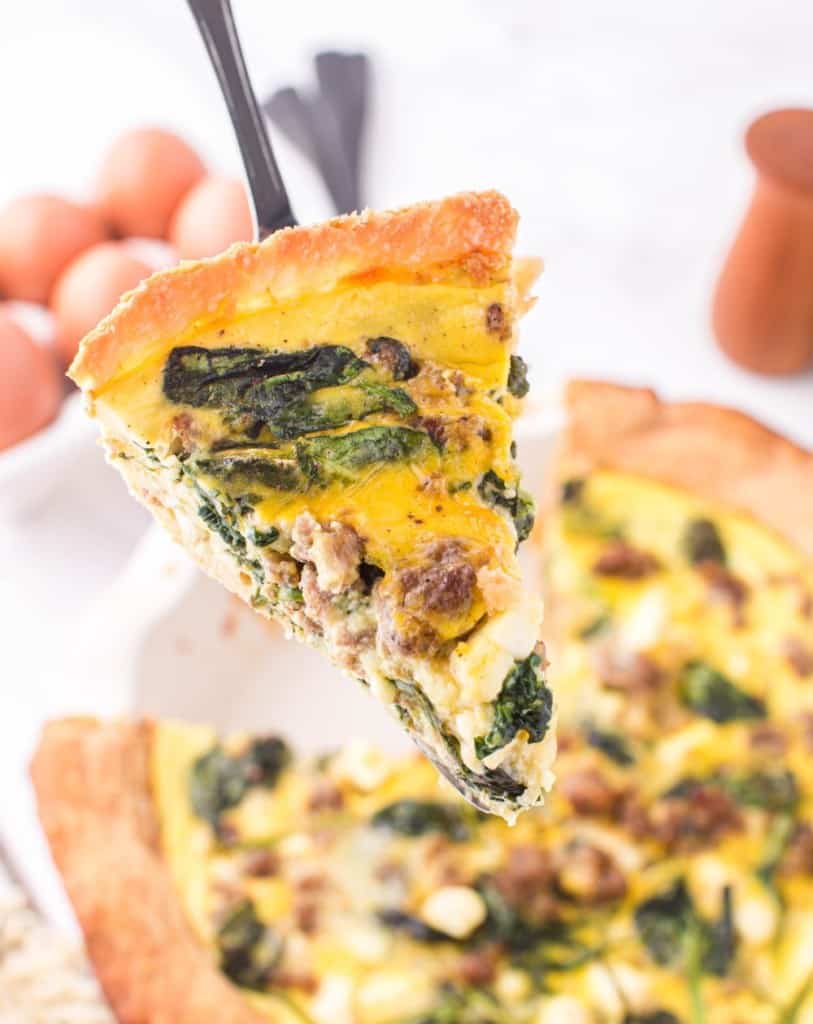 one slice of spinach quiche on a serving spatula