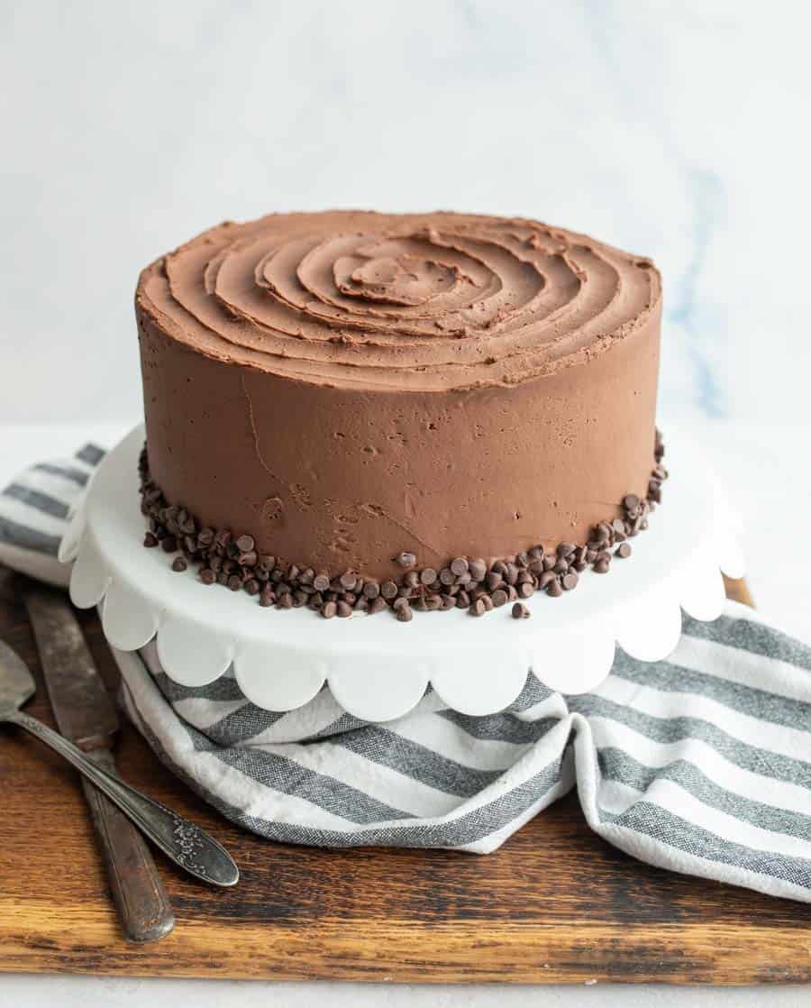 side view of a whole white cake iced with chocolate icing