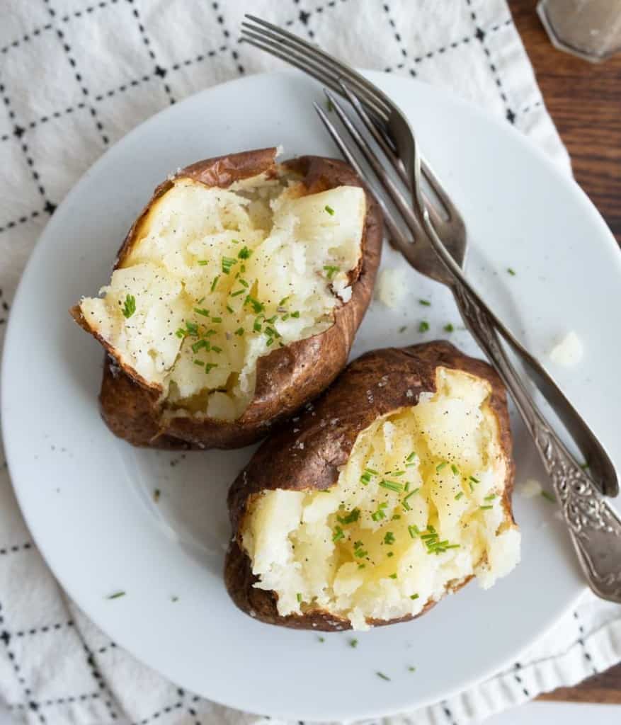 plated air fried baked potato with butter and herbs