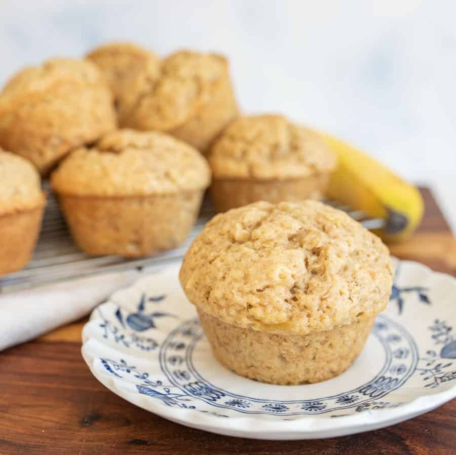 banana bread muffin on a plate with a stack in the background