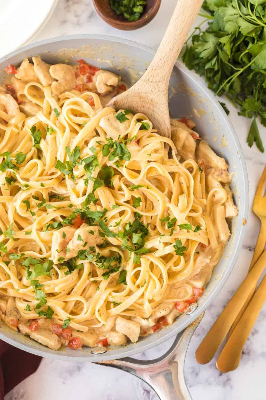 cajun chicken pasta with a wooden spoon in the pan from the top view