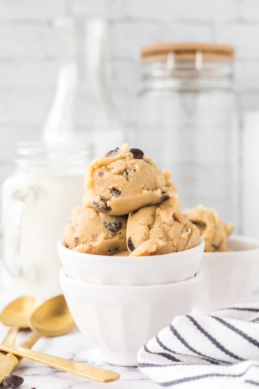 white bowls of round scoops of edible cookie dough