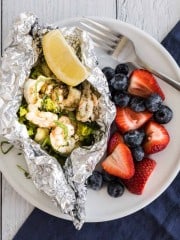 grilled shrimp foil packet dinner on a plate with berries on the side