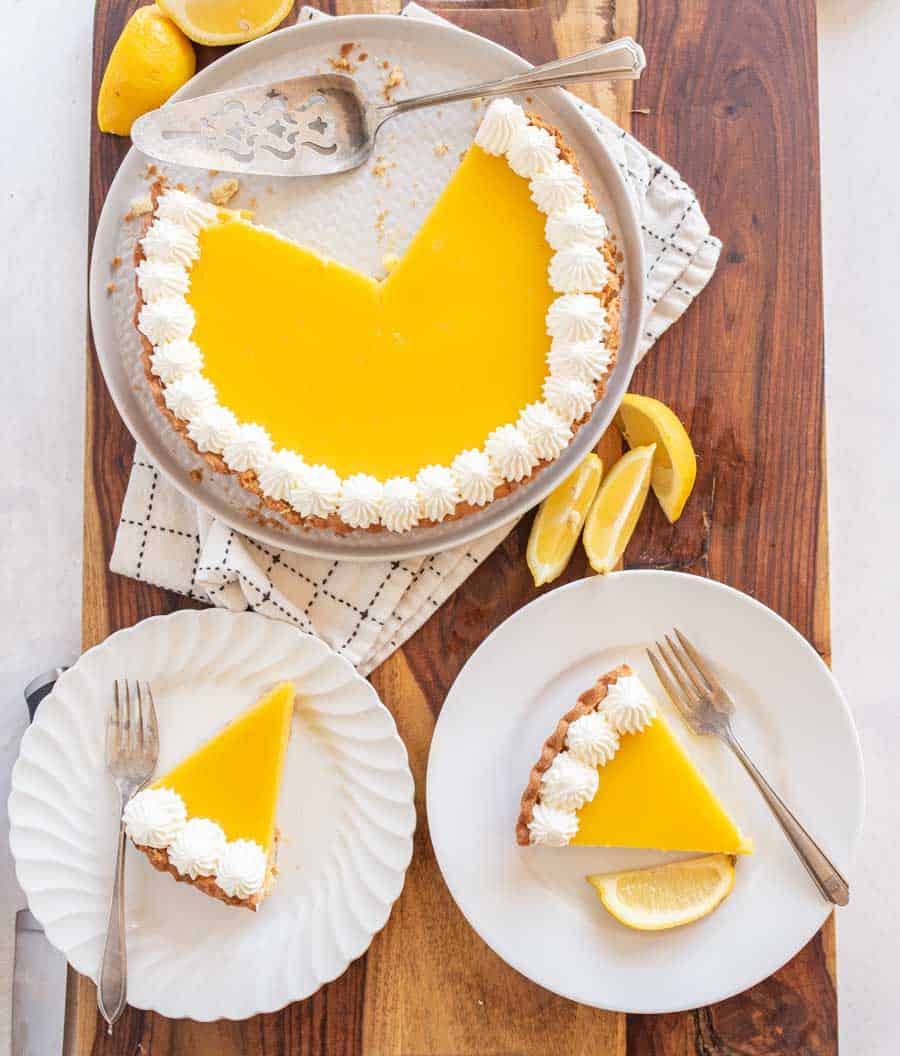 top view of lemon tart with servings dished onto white plates