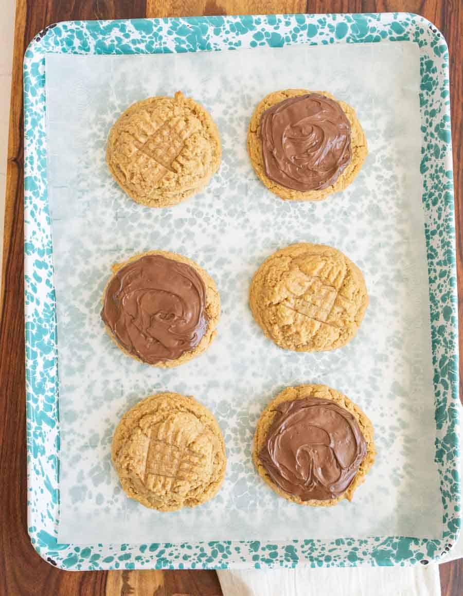 peanut butter nutella cookies some on the baking dish are yet to be iced with nutella