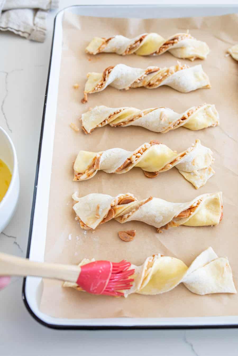 sheet pan with rows of pizza twists ready to bake