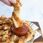 pov dipping, from a plate of pizza twists with marina dipping sauce in the middle