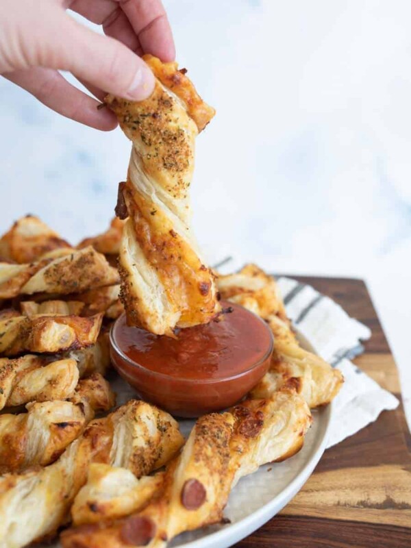 pov dipping, from a plate of pizza twists with marina dipping sauce in the middle