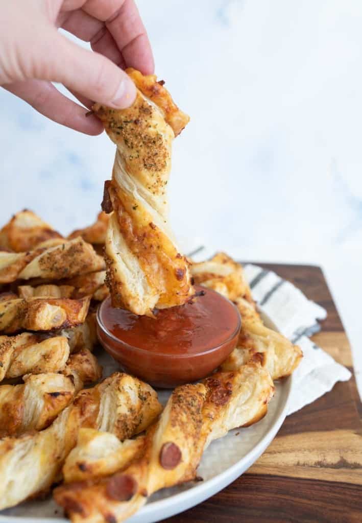 pov dipping, from a plate of pizza twists with marina dipping sauce in the middle