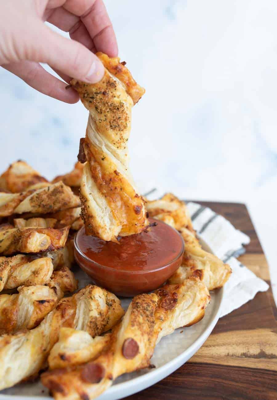 pov dipping, from a plate of pizza twists with marina dipping sauce in the middle