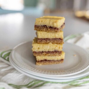 white plate with a stack of raspberry cheesecake bars