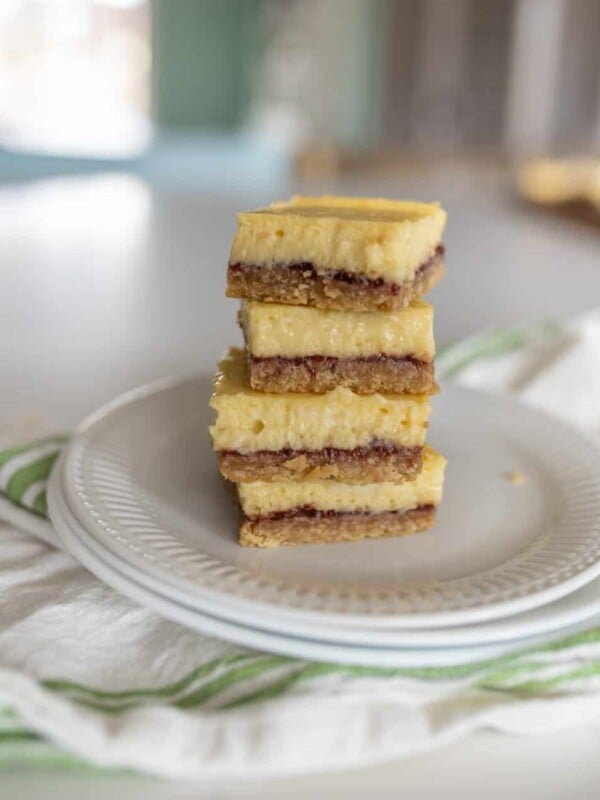white plate with a stack of raspberry cheesecake bars