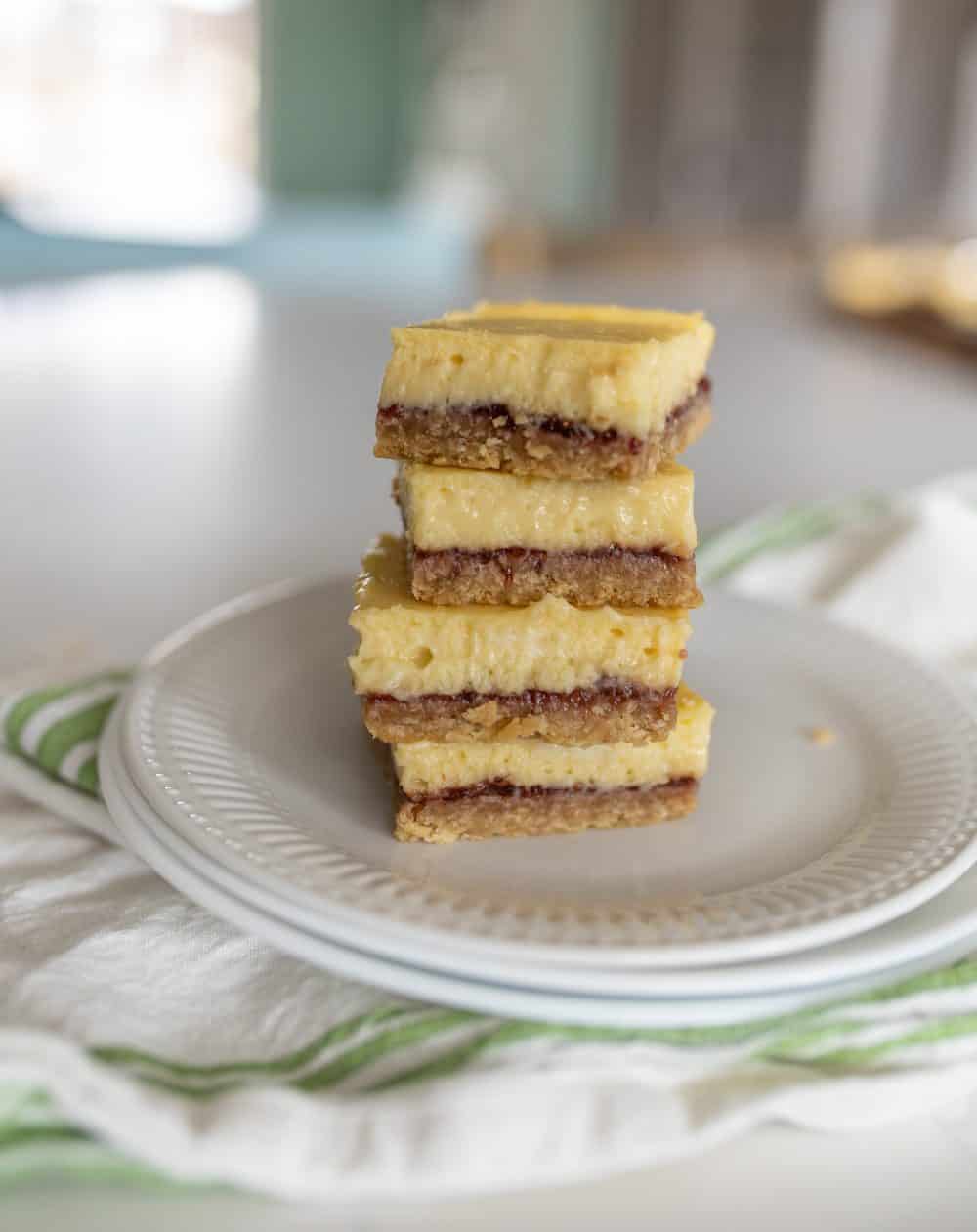 white plate with a stack of raspberry cheesecake bars