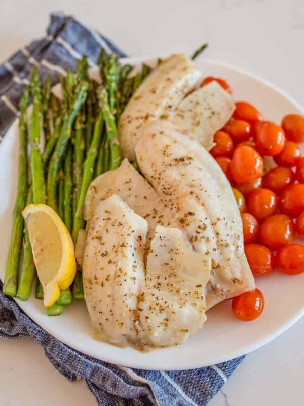 sheetpan tilapia and veggies dinner on a plate