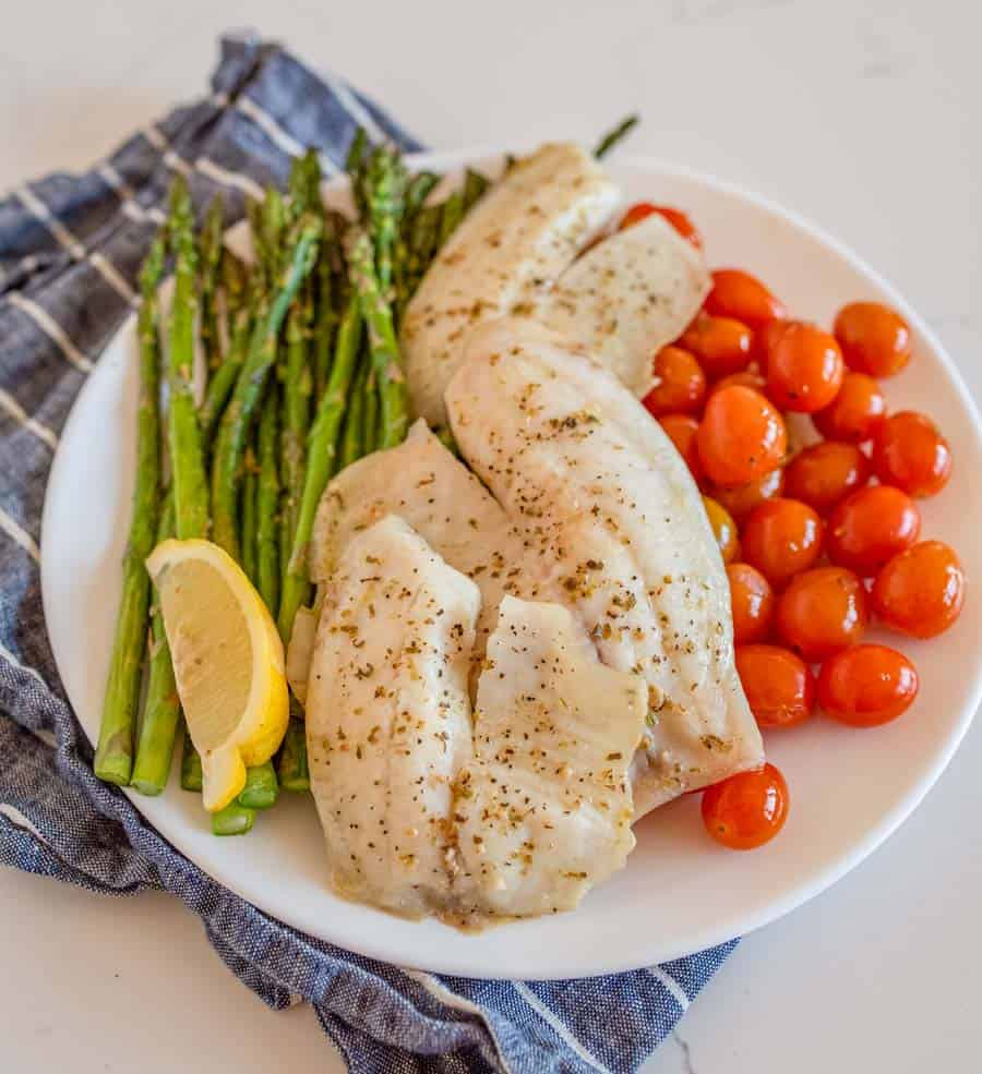 sheetpan tilapia and veggies dinner on a plate