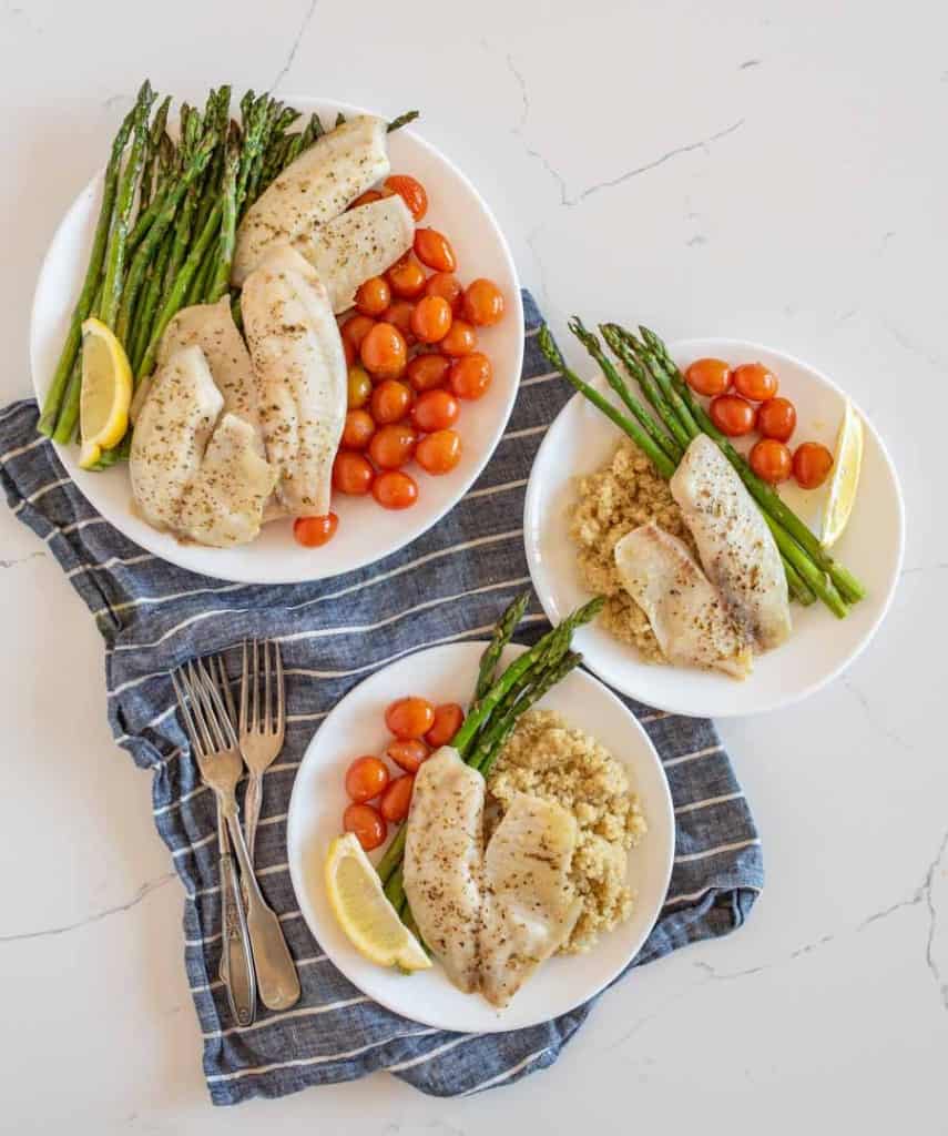 sheetpan tilapia and veggies dinner served on plates