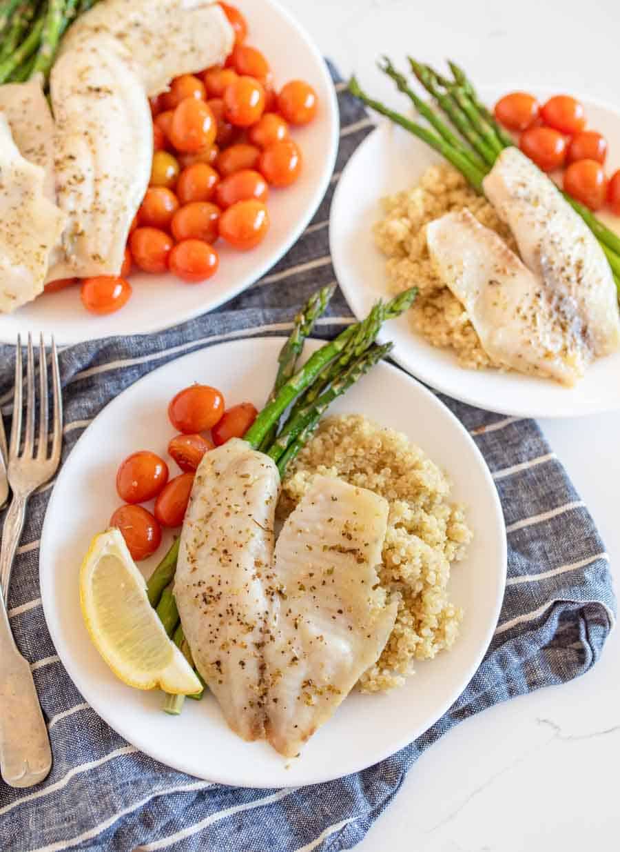 sheetpan tilapia and veggies dinner served on plates