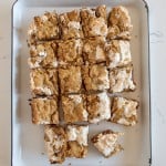 smores cookie bars cut into squares and on a white plate.
