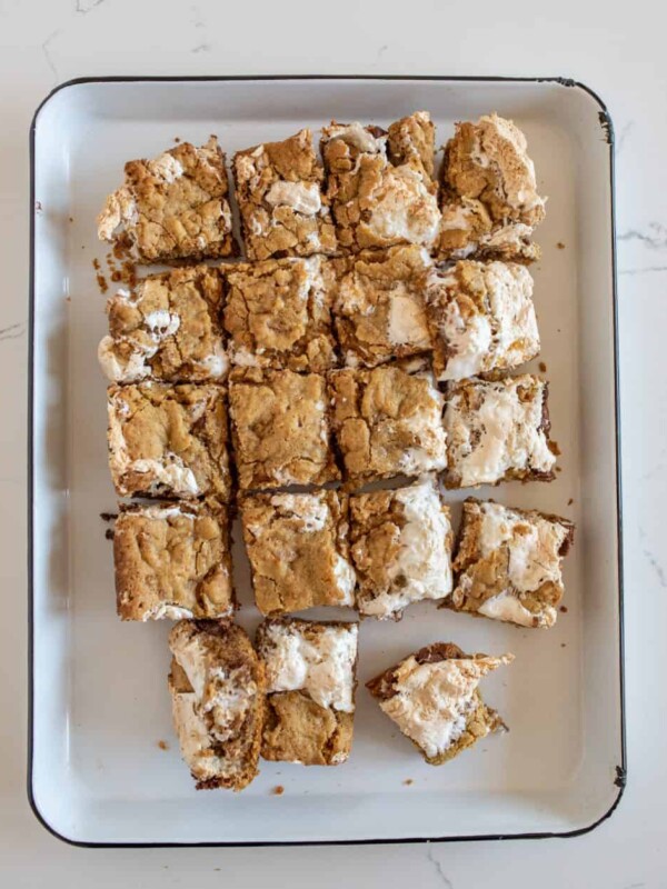 smores cookie bars cut into squares and on a white plate.