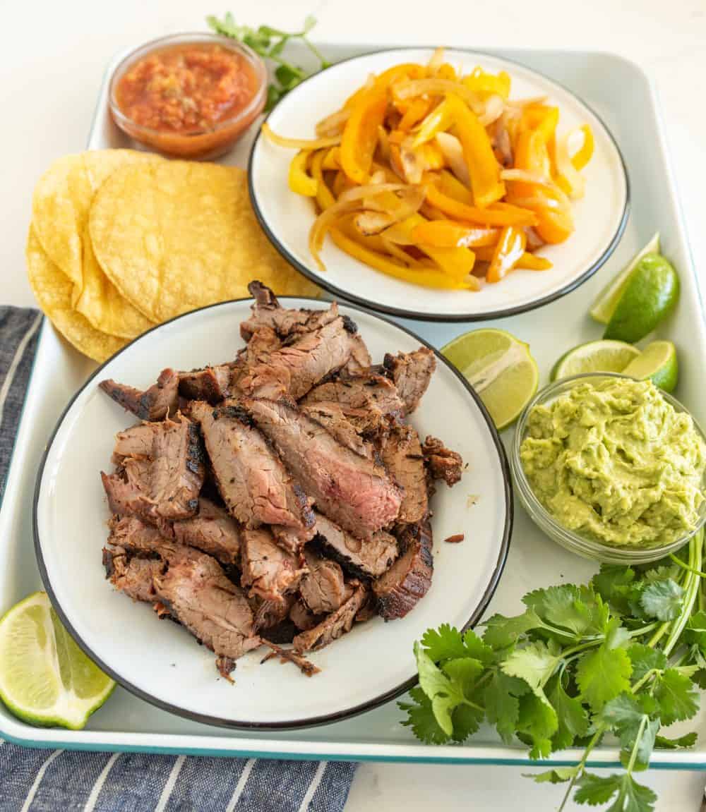 Image of a platter of steak fajitas and all the toppings