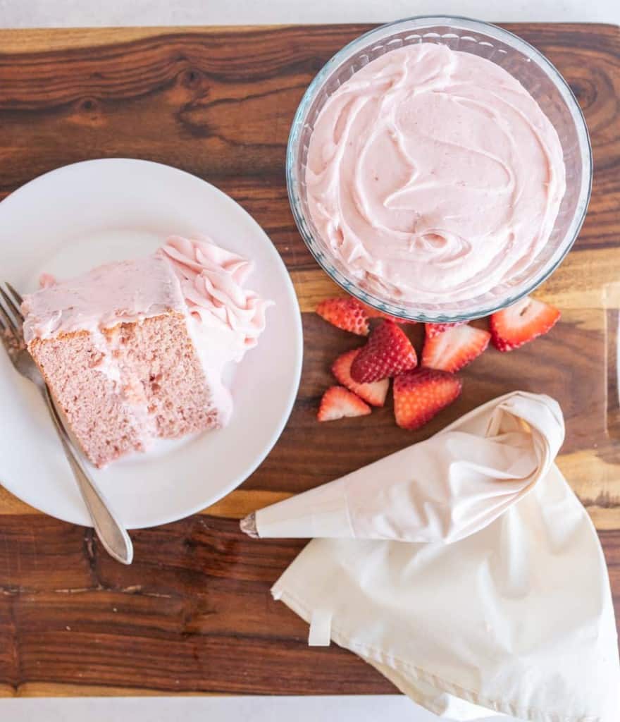 a bowl and piping bag filled with strawberry buttercream