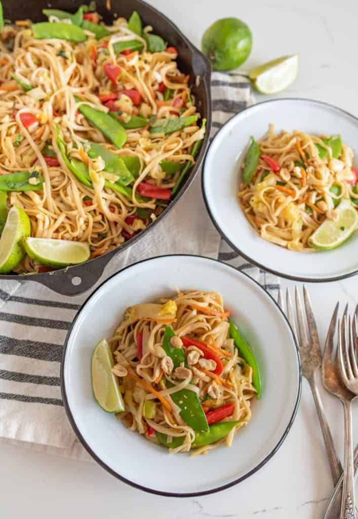 veggie lo mein in bowls served from the cast iron pan