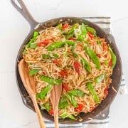 veggie lo mein in bowls served from the cast iron pan