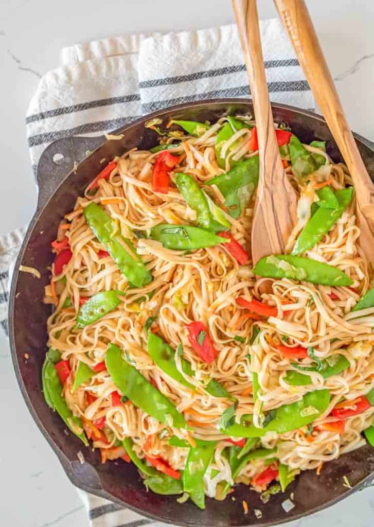 veggie lo mein in bowls served from the cast iron pan