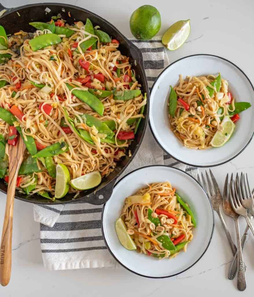 veggie lo mein in bowls served from the cast iron pan