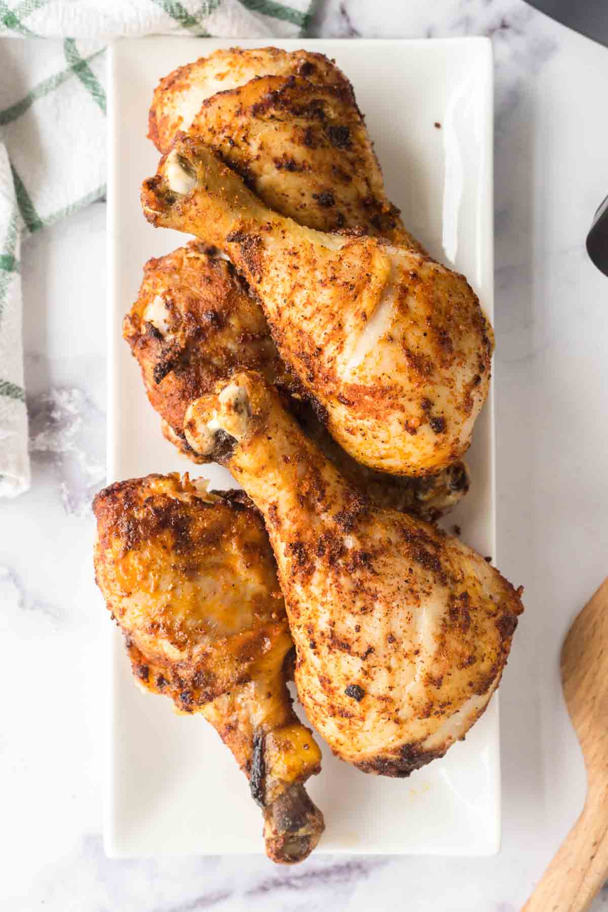 crispy chicken legs stacked on a white plate