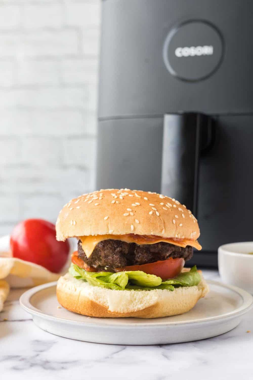 side view of an air fryer hamburger on a white plate