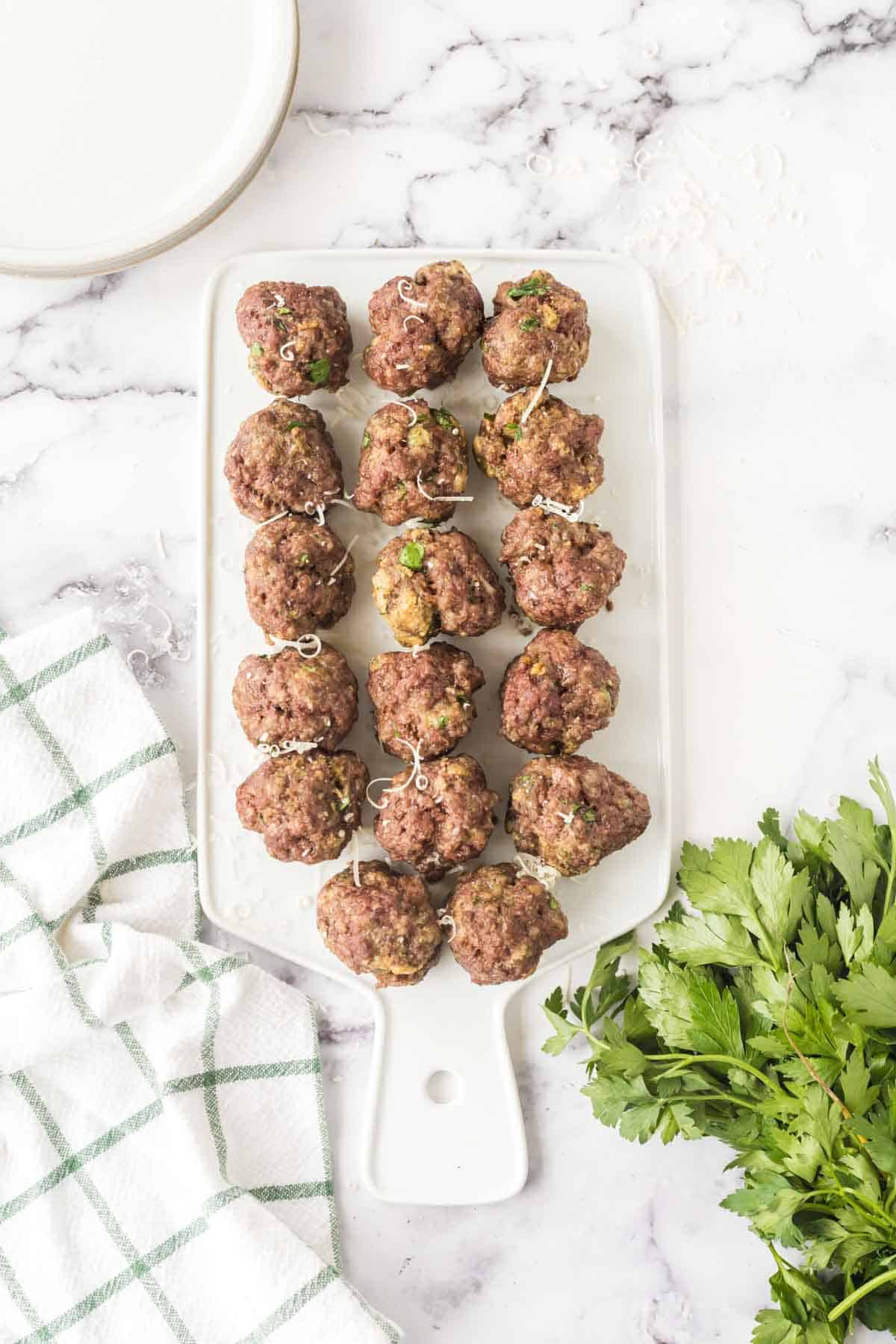 top view of baked meatballs in rows on a platter