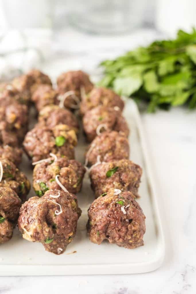 close up of baked meatballs in rows on a platter