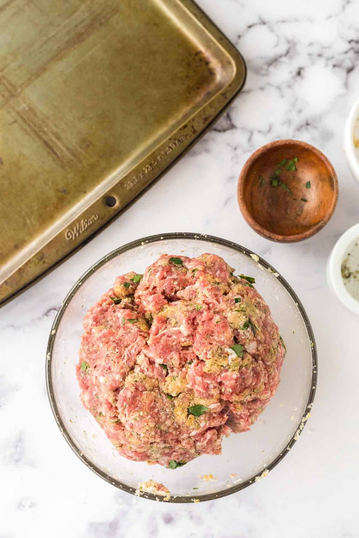 raw meatball mix in a clear bowl