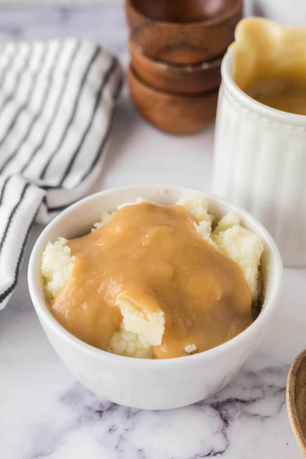 mashed potatoes and brown gravy in a white bowl