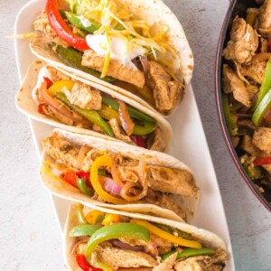 4 chicken fajitas with peppers and onions in a flour tortilla