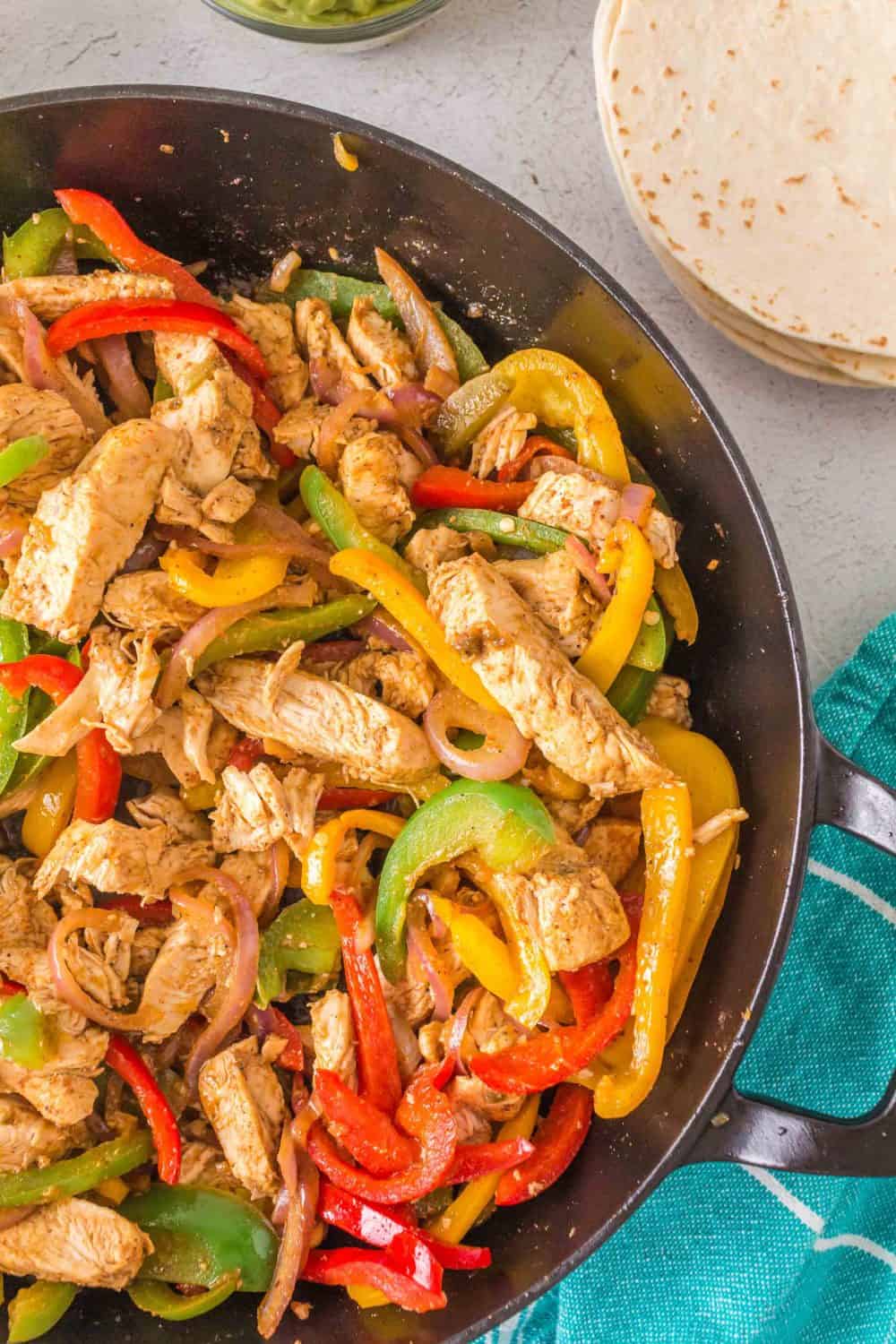 Chicken fajitas with onions and bell peppers in a pan