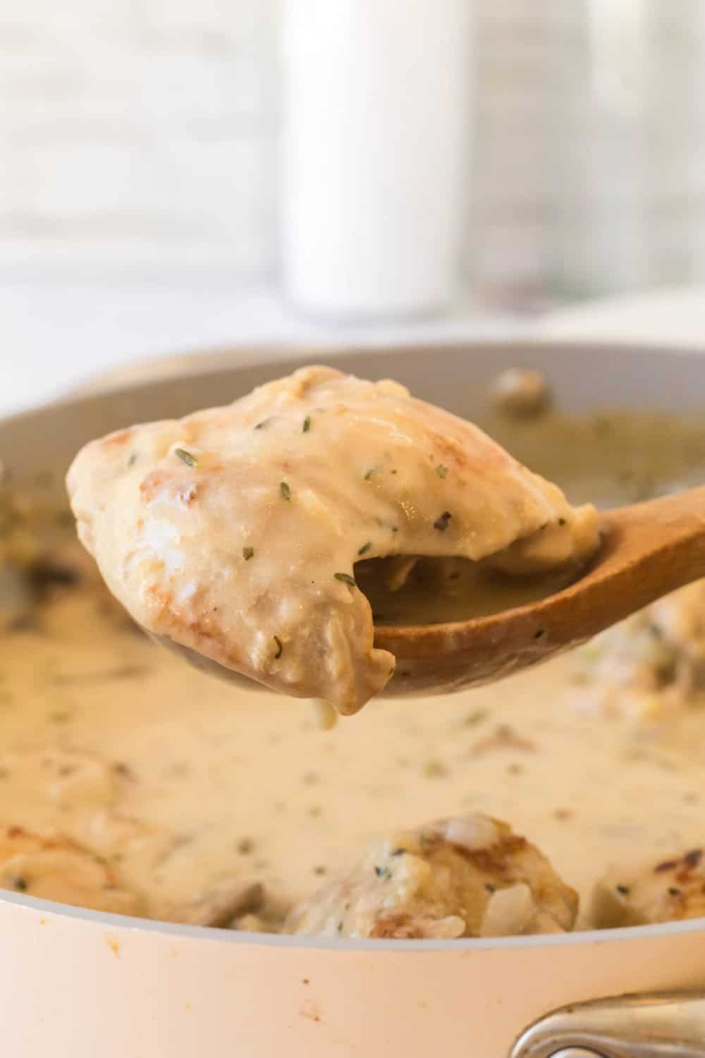 side view of chicken fricassee being spooned out of the cooking pan