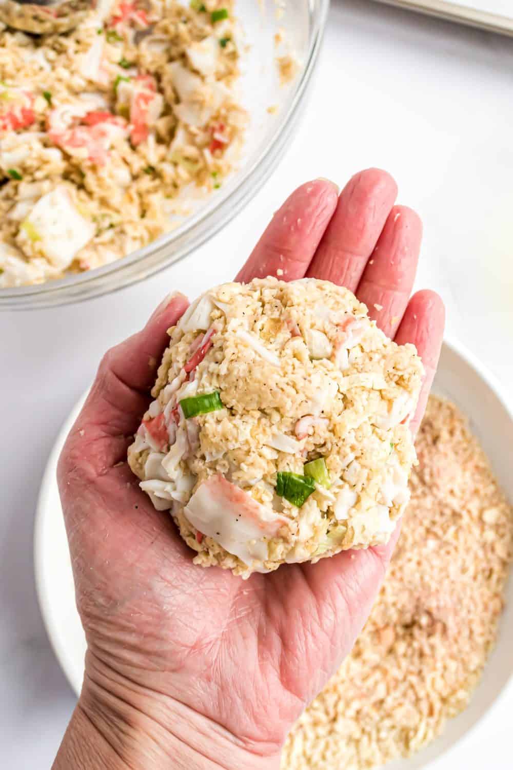 a hand holding a crab cake.