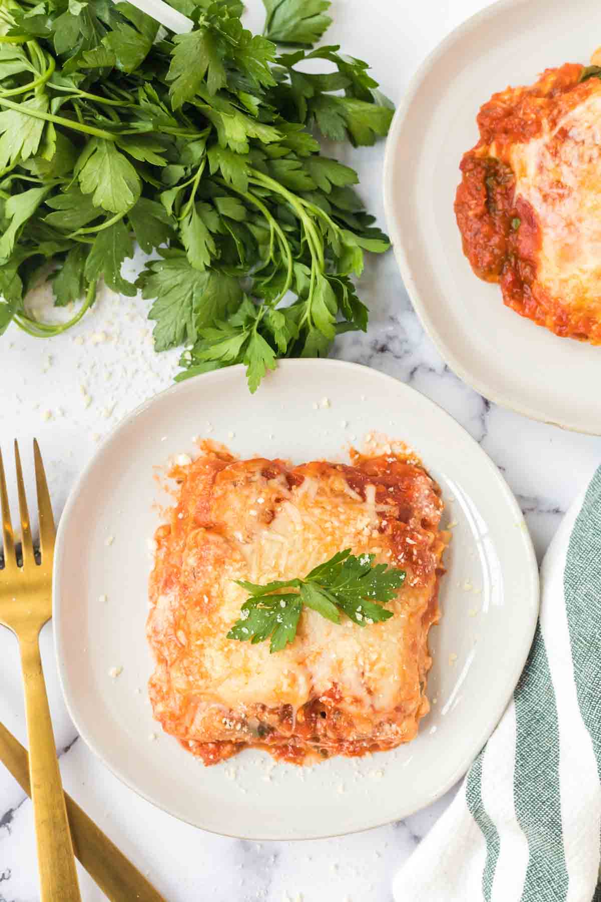 top view of a white plate with one square serving of lasagna