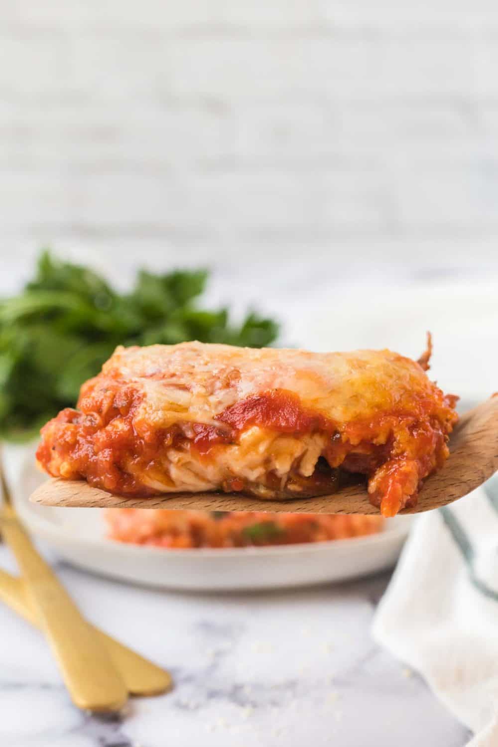 wooden spoon with one square serving of lasagna