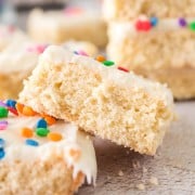 sugar cookie bars with white frosting and rainbow sprinkles