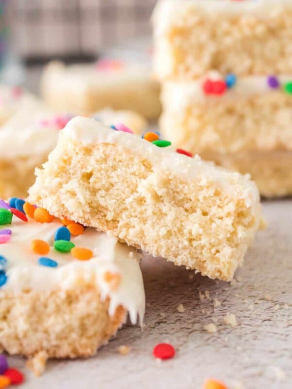 sugar cookie bars with white frosting and rainbow sprinkles