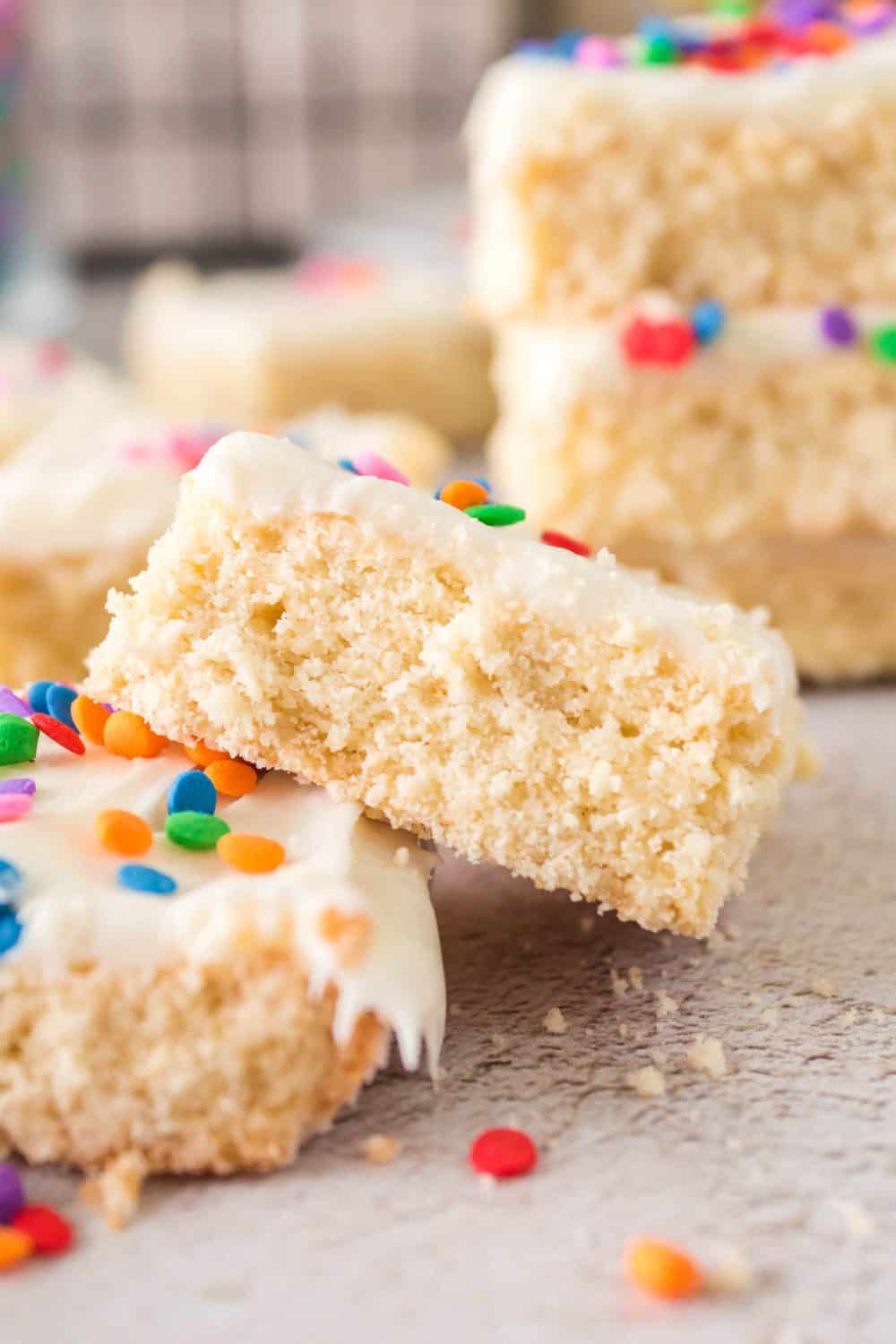 sugar cookie bars with white frosting and rainbow sprinkles